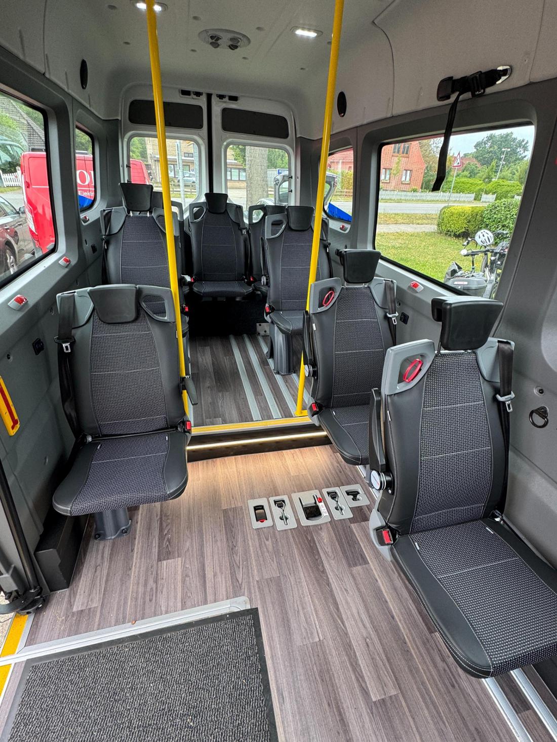 Blick in den Innenraum des BürgerBus Wildeshausen mit Fahrgastsitzen und gelben Haltestangen